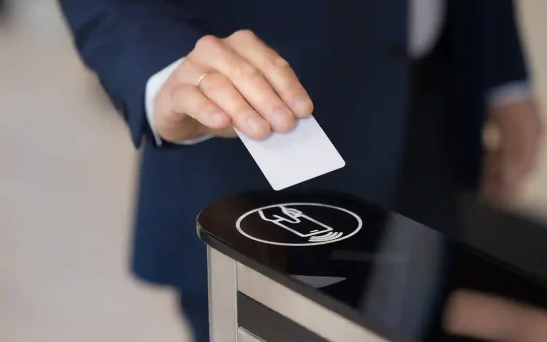 Mano de empresario apoyando tarjeta de control de acceso sobre sensor de un lector corporativo