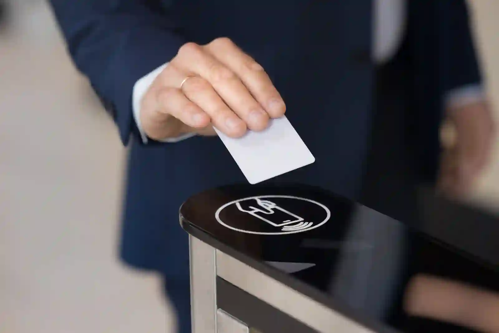 Mano de empresario apoyando tarjeta de control de acceso sobre sensor de un lector corporativo