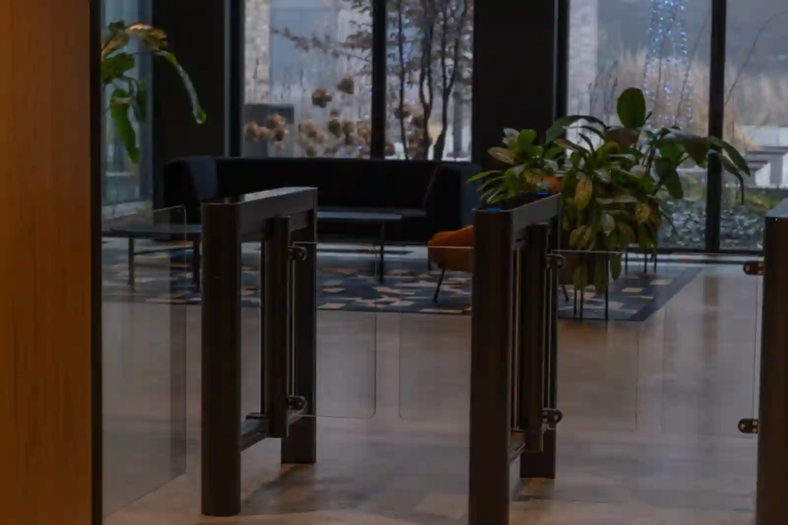 Lobby corporativo moderno con molinetes de control de acceso y vegetación interior premium