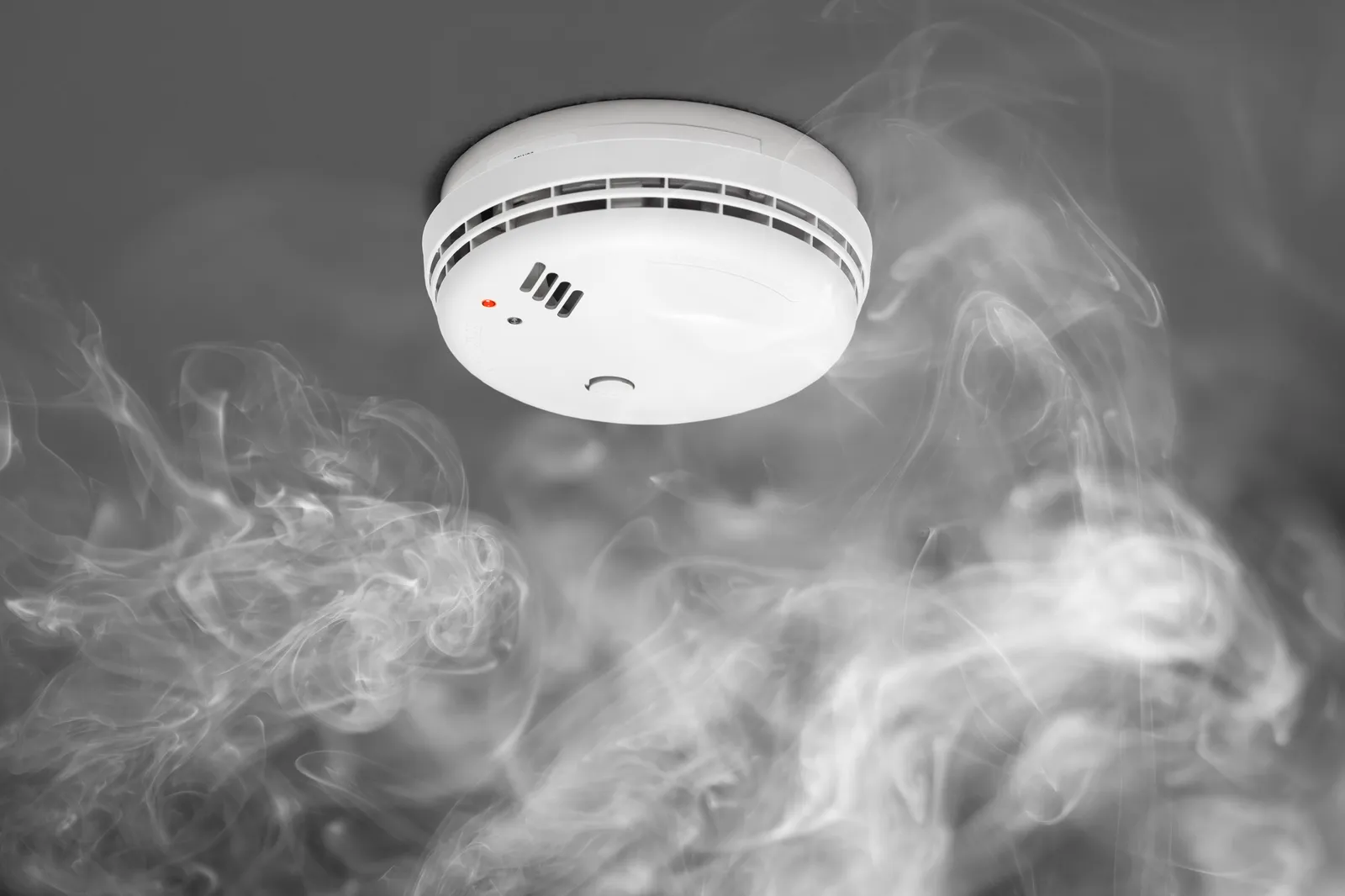 Detector de humo en techo activado emitiendo alarma de incendio