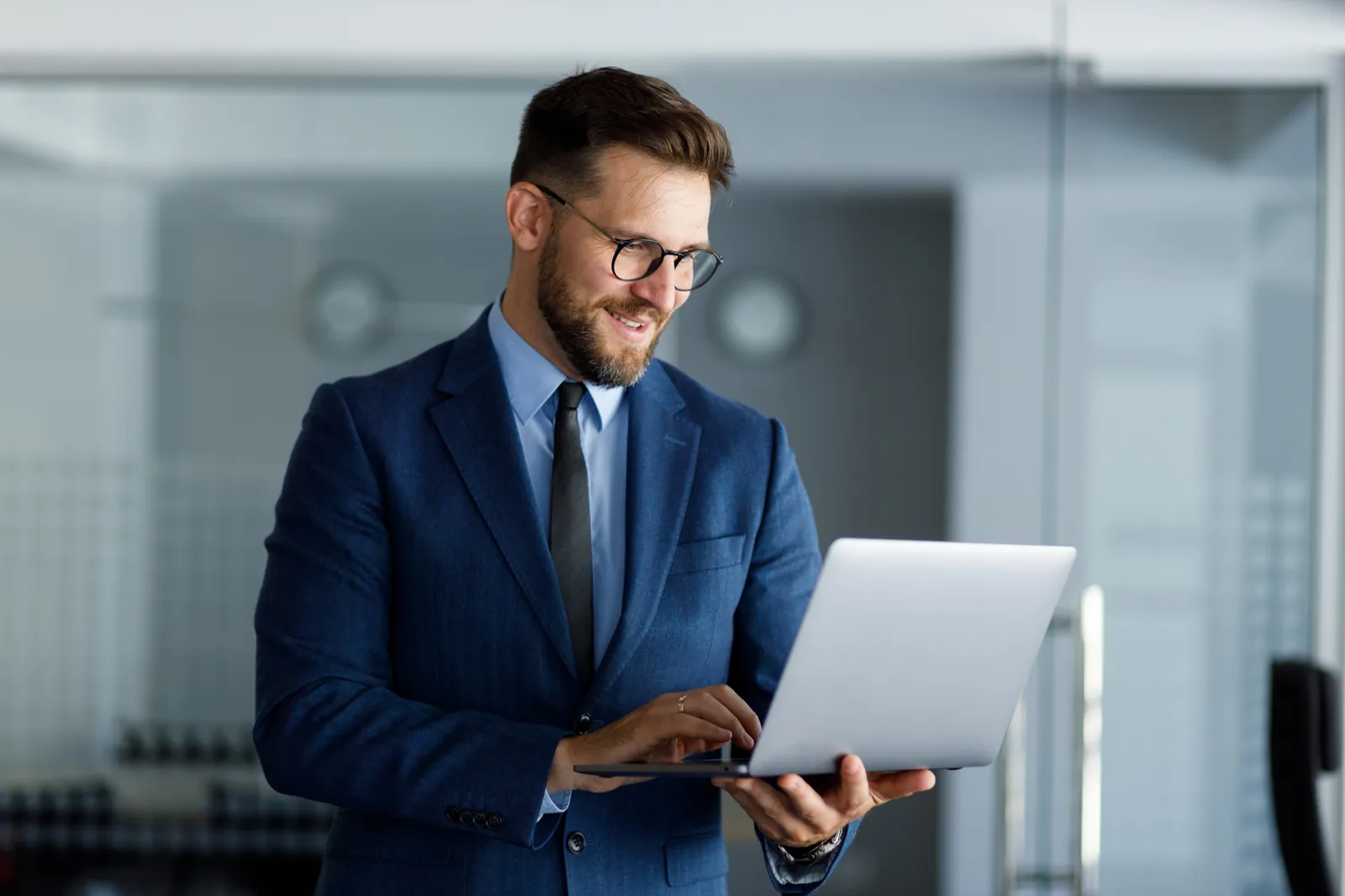 Gerente de seguridad corporativo analizando reportes y KPIs del plan integral en laptop en oficina moderna