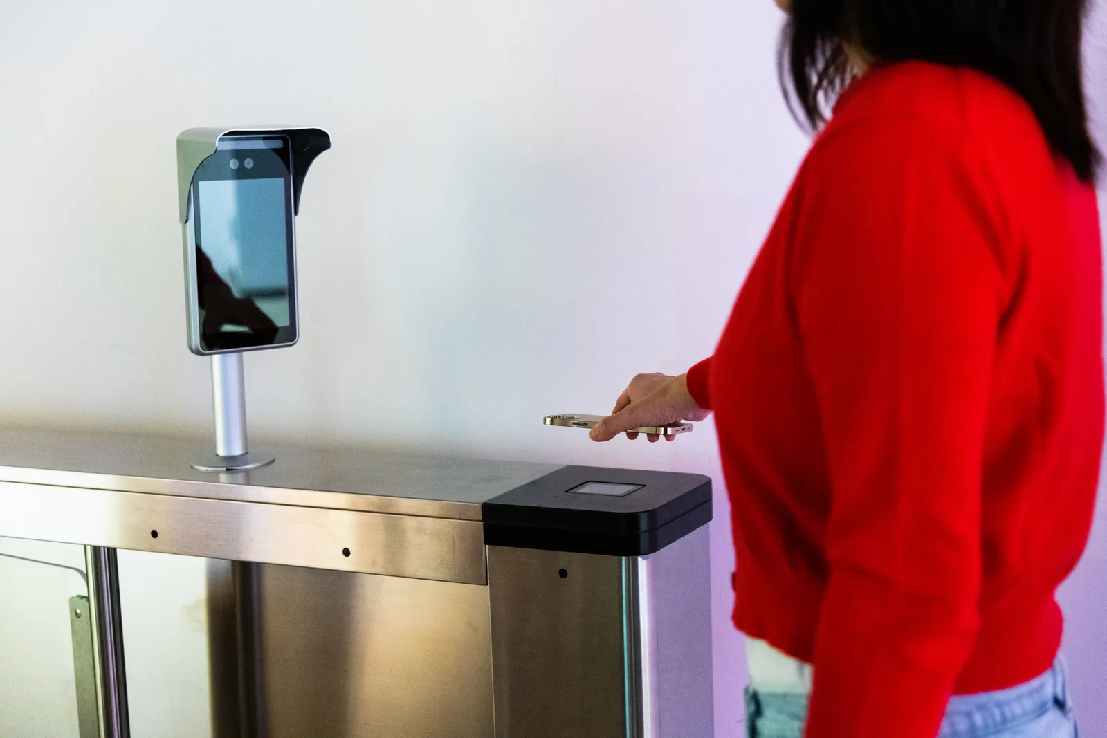 Control de acceso para coworking: socia acercando el celular al lector del molinete de ingreso