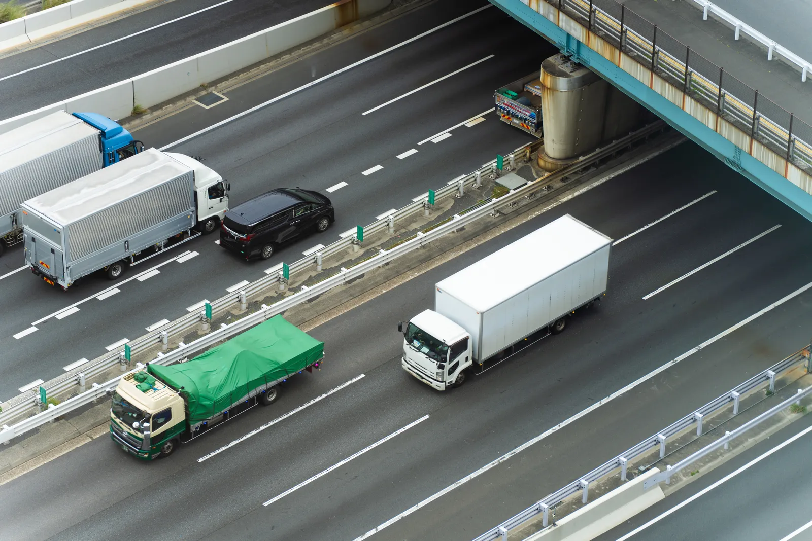 Flota de camiones de carga circulando por una autopista vista desde el aire