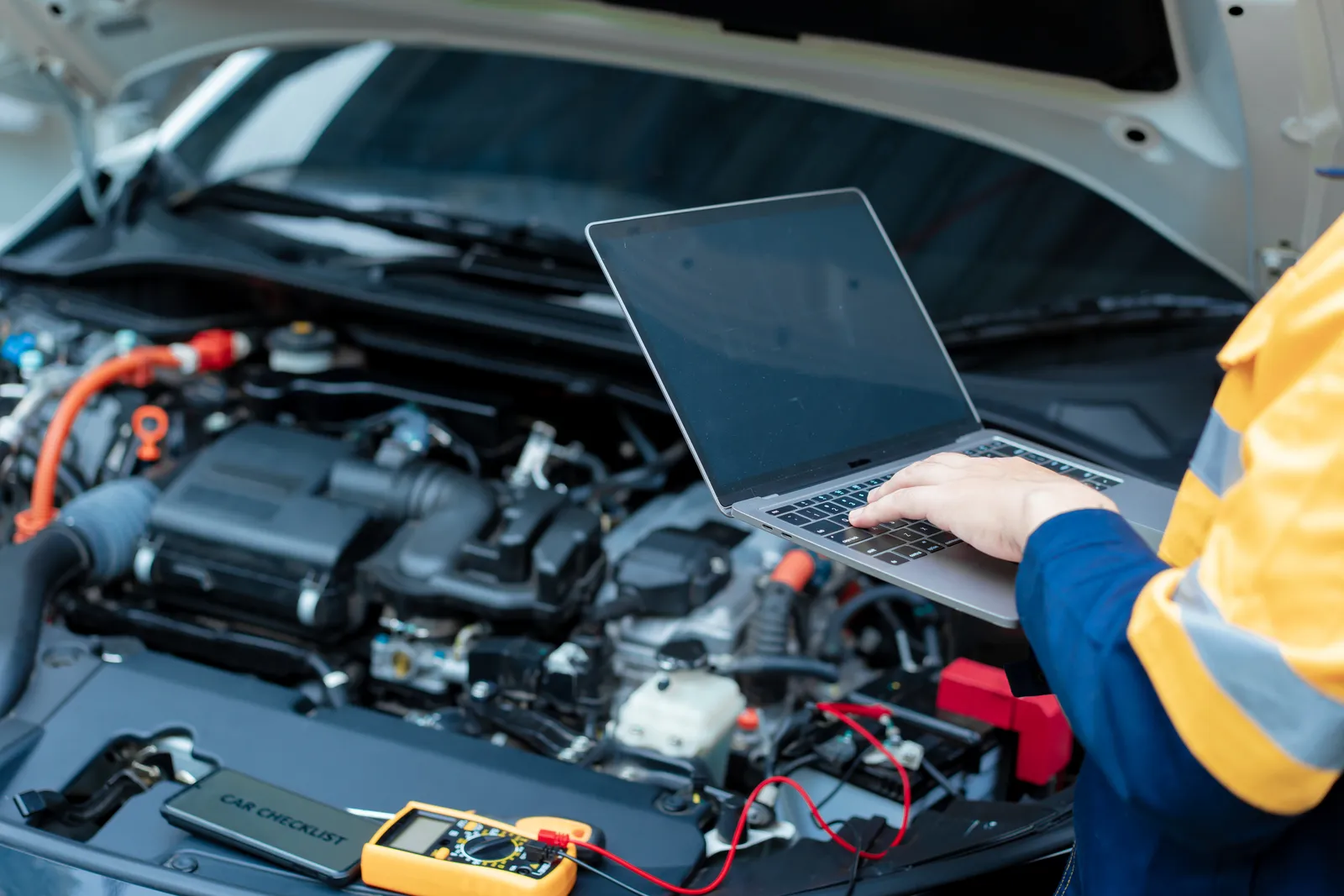 Técnico revisando con una laptop los sistemas electrónicos de un vehículo de flota