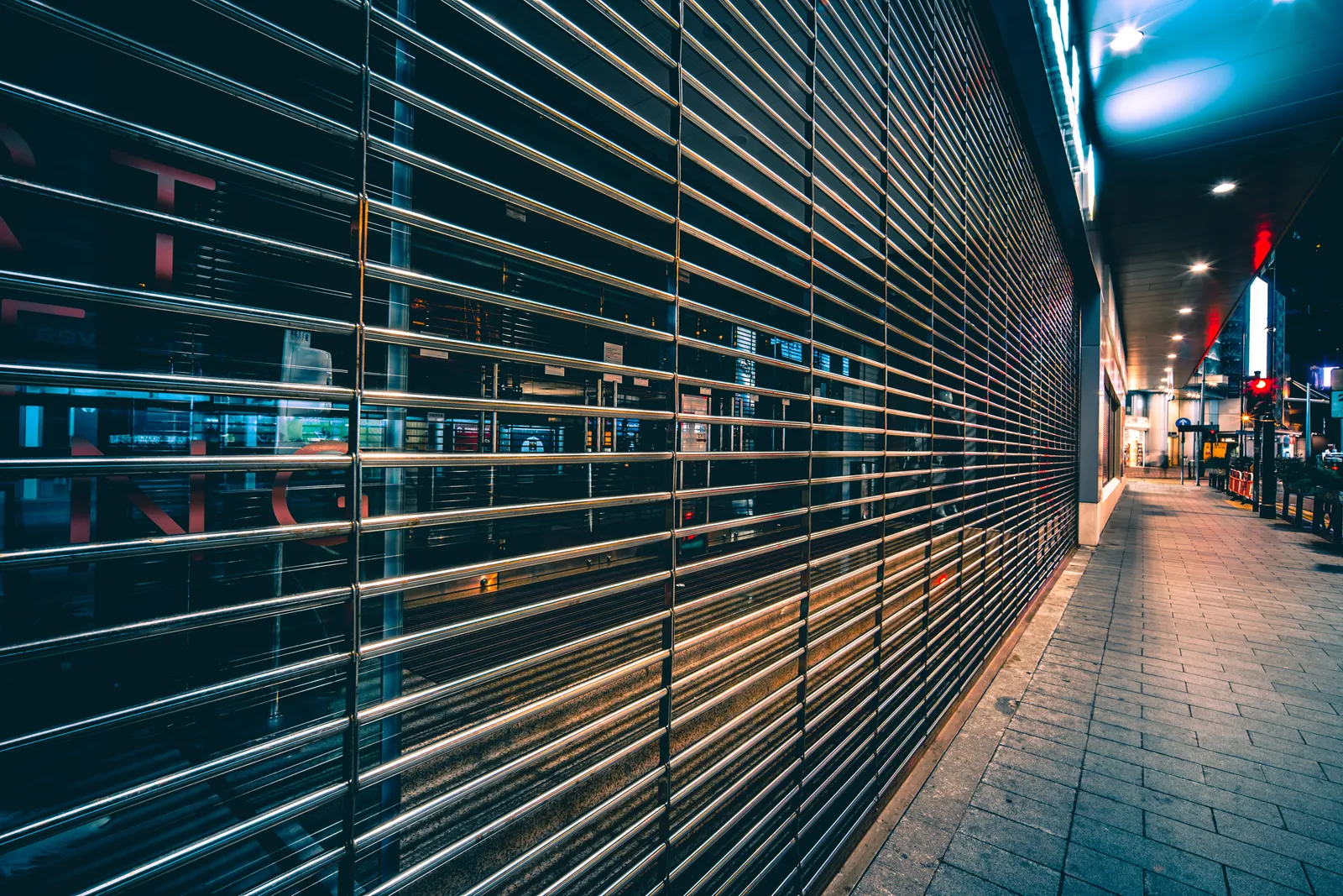 Persianas metálicas cerradas de una fila de locales comerciales durante la noche