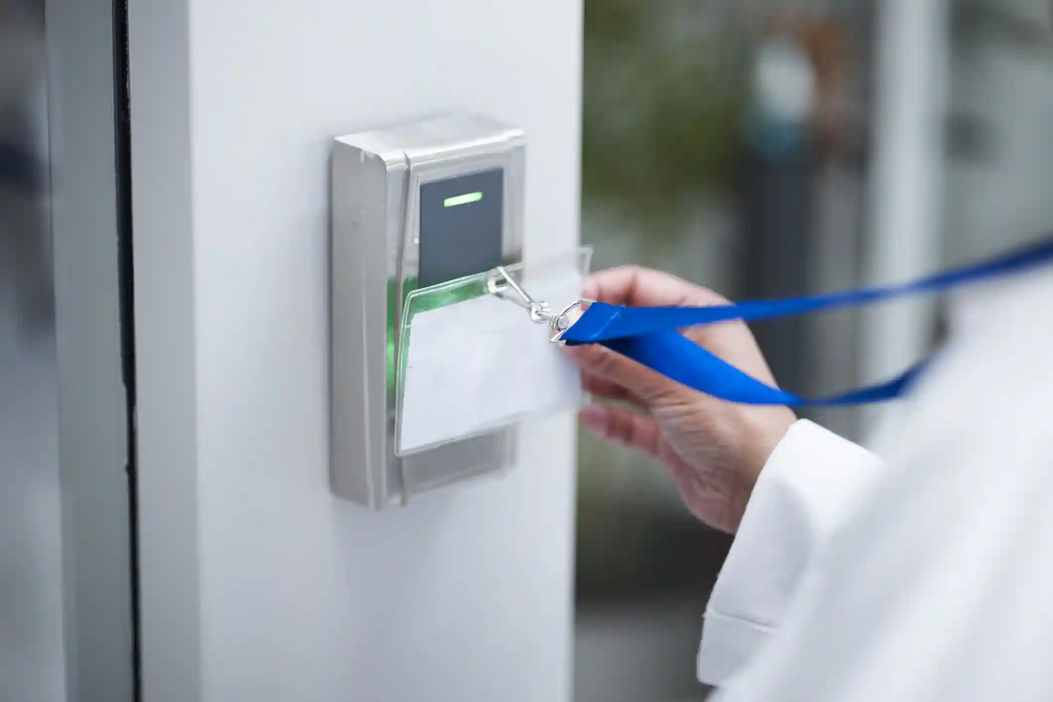 Persona apoyando una credencial personal en un lector de control de accesos