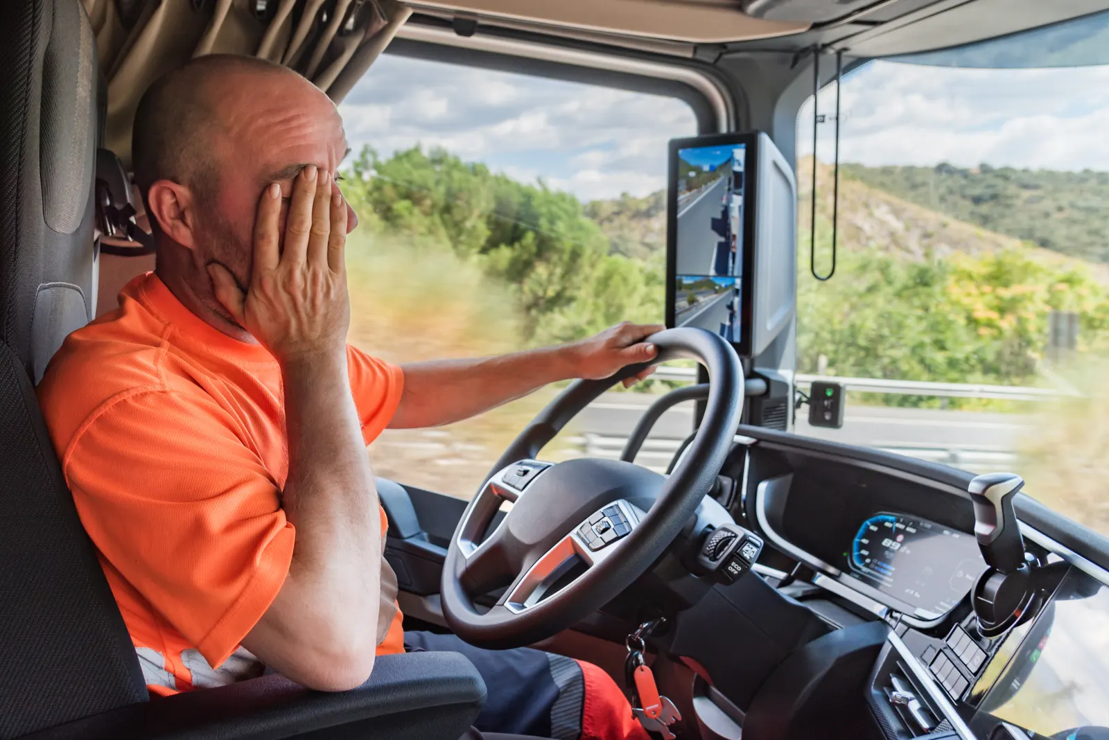 Chofer de camión con signos de cansancio frotándose los ojos al volante
