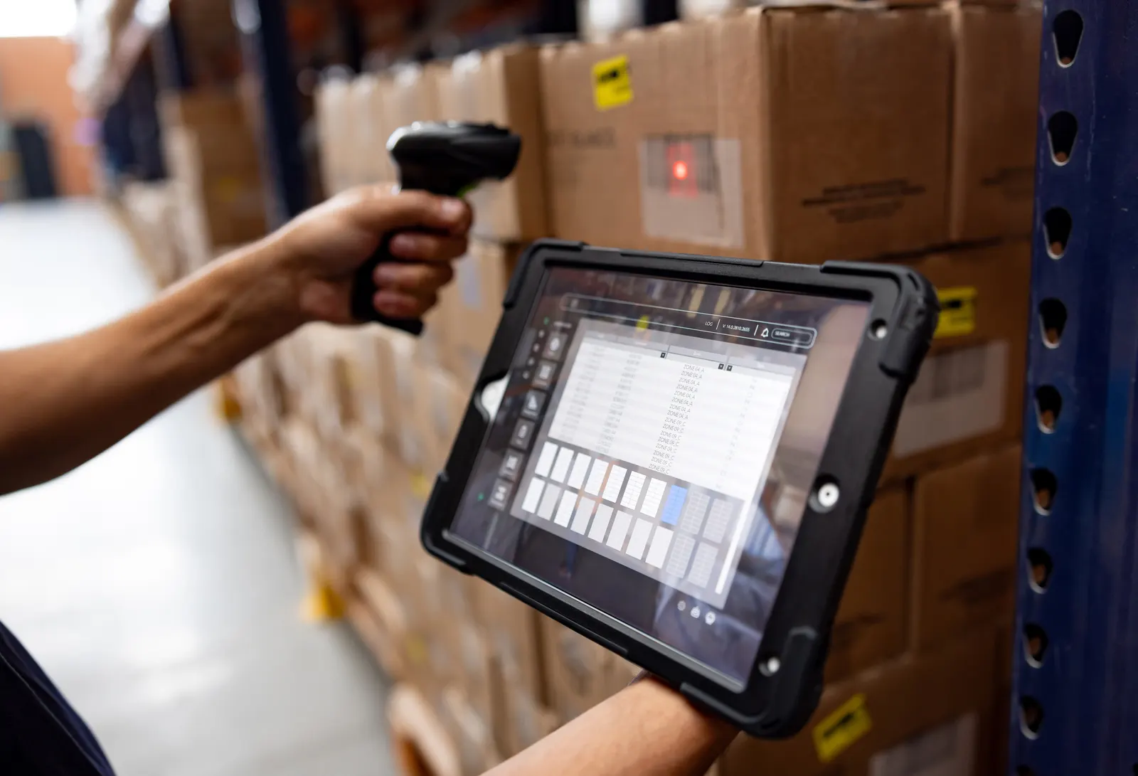 Operario de depósito haciendo inventario con lector de mano y tablet