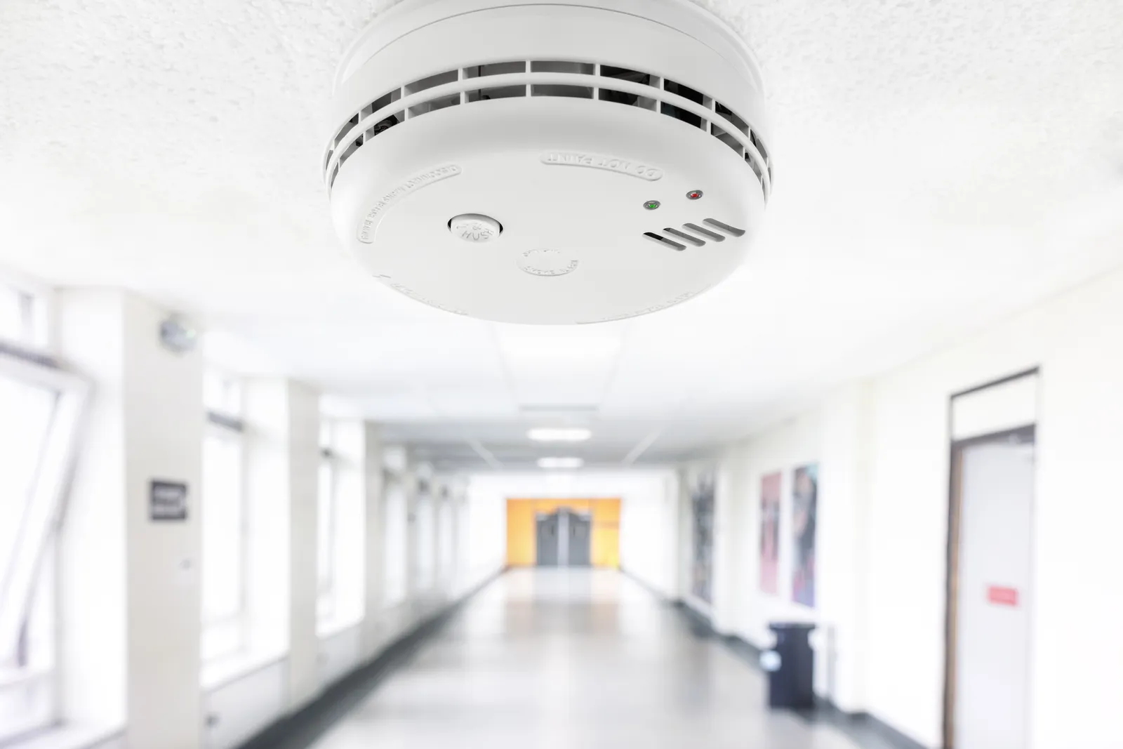 Detector automático de humo instalado en el techo del pasillo de un edificio de salud