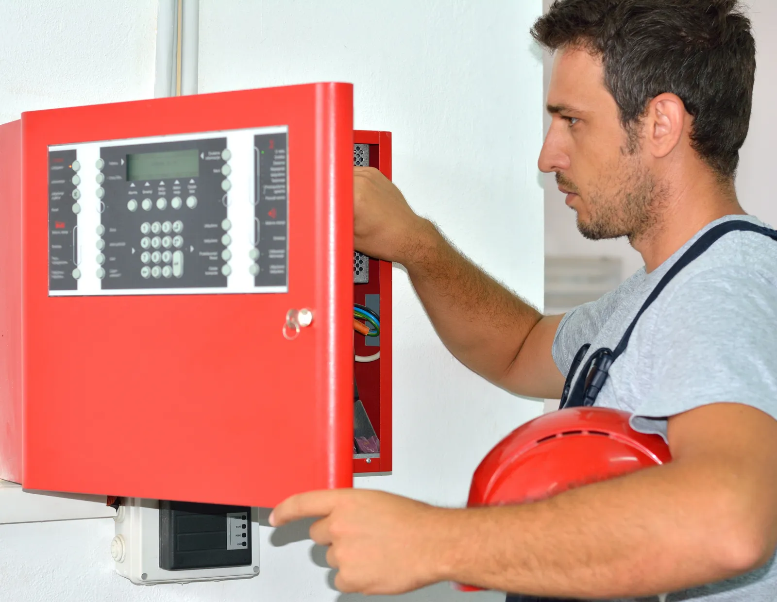 Técnico revisando la central de detección de incendios de un edificio institucional