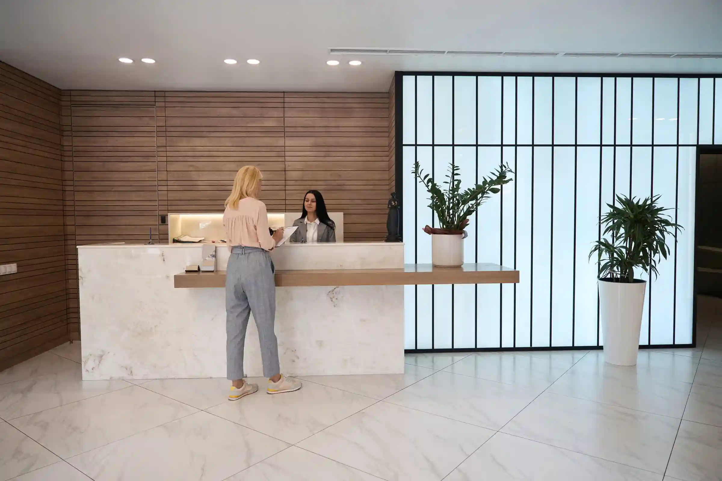 Visitante registrándose en la recepción de un edificio de oficinas